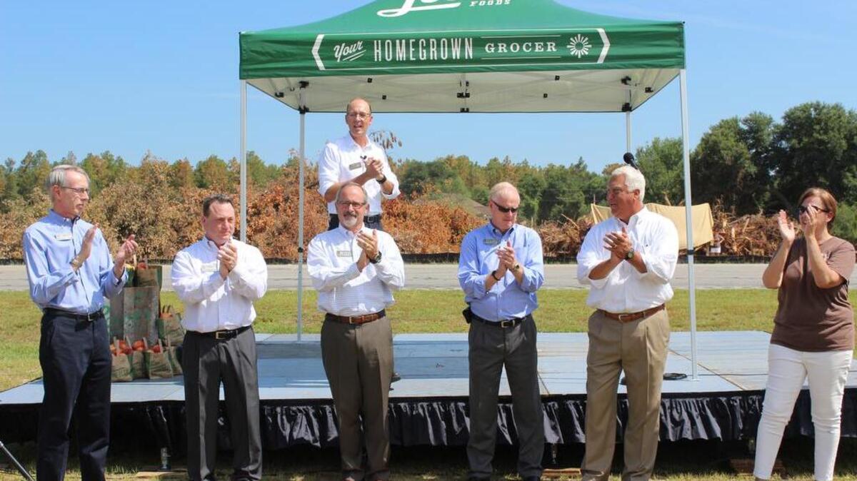 Lowes Foods president Tim Lowe, upper row center, is joined by company employees and Lexington leaders in official groundbreaking for two new grocery stores in the Columbia market.