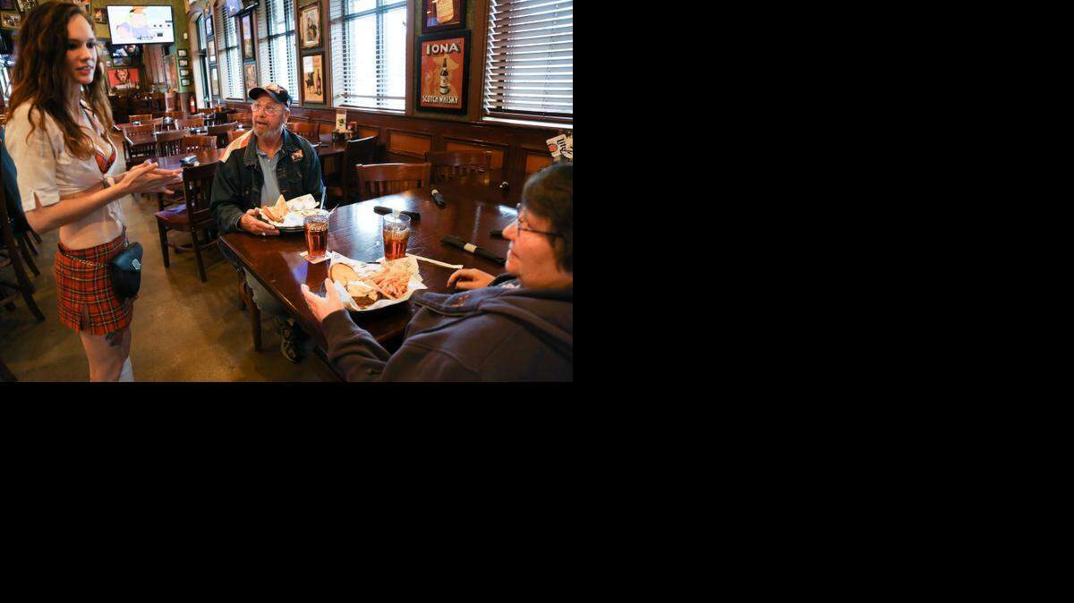 
Waitress Claudia White talks with customers, Ron and Linda Van De Weerd at Tilted Kilt in Irmo. 
