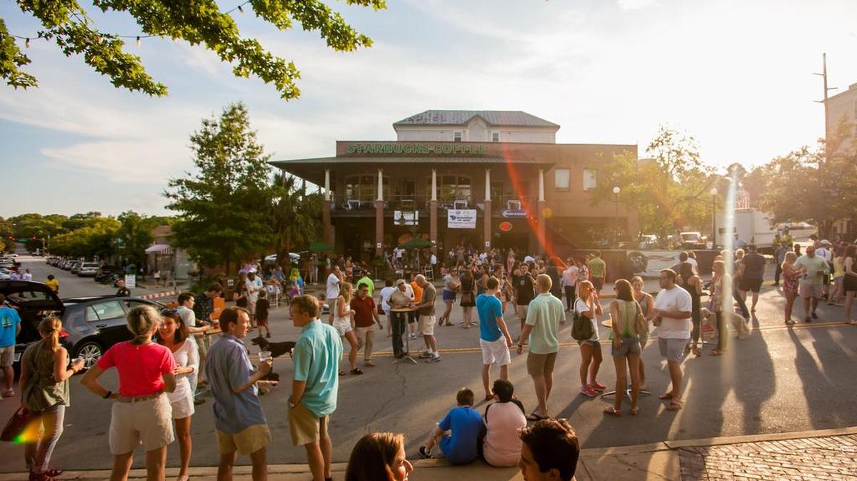 Attendees listen to a band perform during a free outdoor local concert series in May 2015 hosted at the fountain in Five Points.