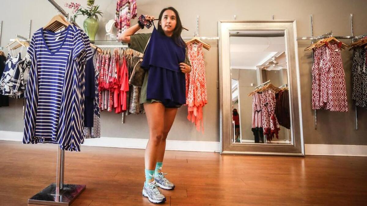 
Adrienne Helbing tries on a dress at Wish in Five Points on Friday. Shoppers took advantage as tax-free weekend got started. 
