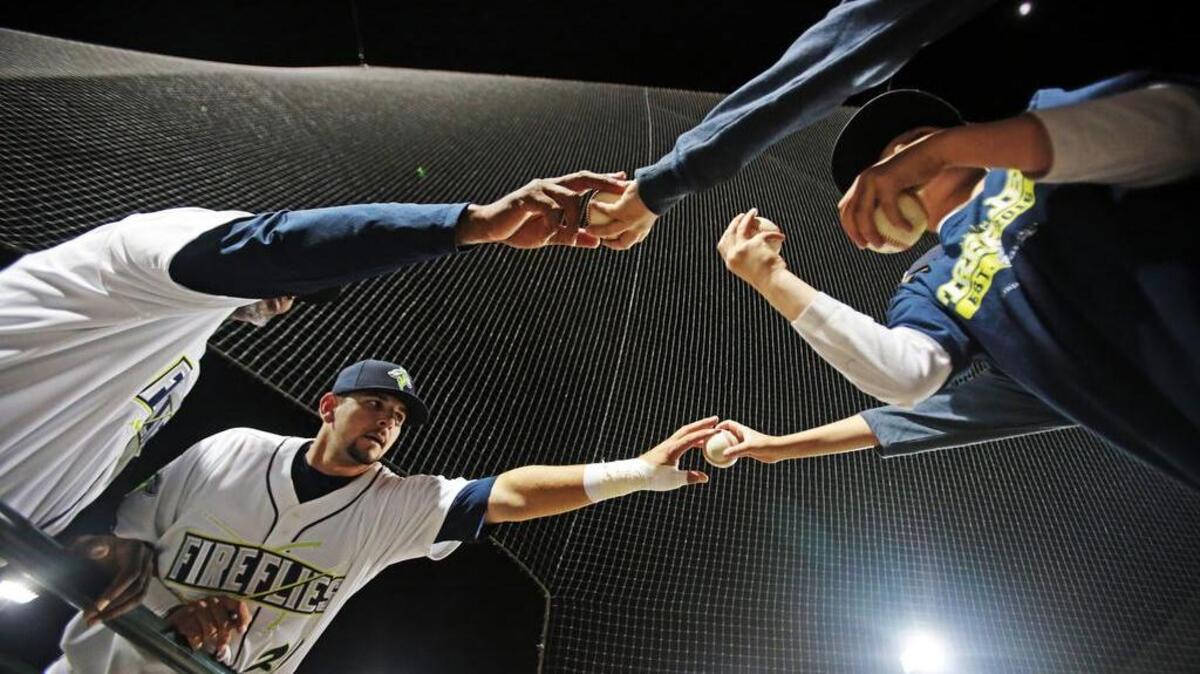 Fireflies players sign autographs after a win against Greenville at Spirit Communications Park in April.