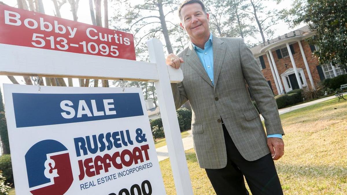 Real estate agent Bobby Curtis is shown with a Russell & Jeffcoat home listing in Columbia.