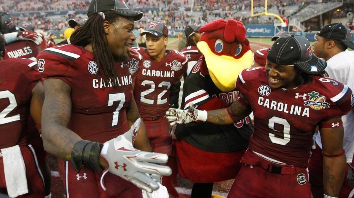 Jadeveon Clowney, left, and linebacker Sharrod Golightly celebrate the Gamecocks’ win over Wisconsin in the Capital One Bowl game on Jan. 1, 2014.
