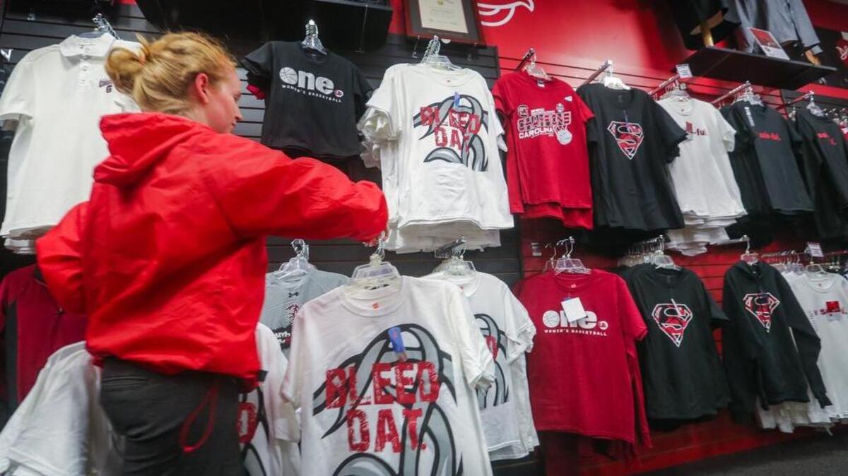 FILE PHOTO: As a result of the great season and the trip to the Final Four, the South Carolina Women's Basketball apparel and other Gamecock related gear is a hot item in stores. Bianca Dunn, a sales associate with Garnet and Black Traditions, restocks one of the more popular t-shirts.