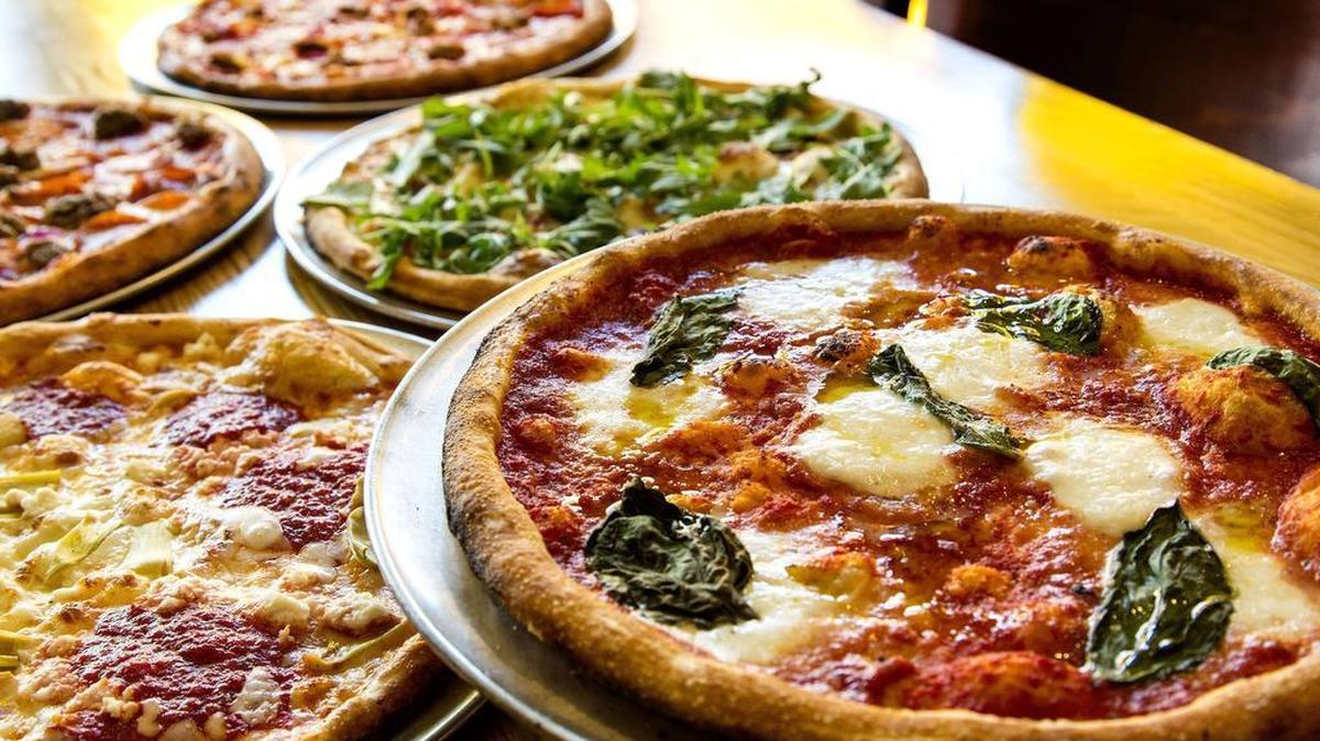 
Some of Blaze’s signature pizzas: The Red Vine is made with ovalini mozzarella, cherry tomatoes, Parmesan, basil, tomato sauce and an olive oil drizzle (far right); the Art Lover has artichokes, mozzarella, ricotta, chopped garlic and tomato sauce dollops (lower left). (Ricardo DeAratanha/Los Angeles Times/MCT)
