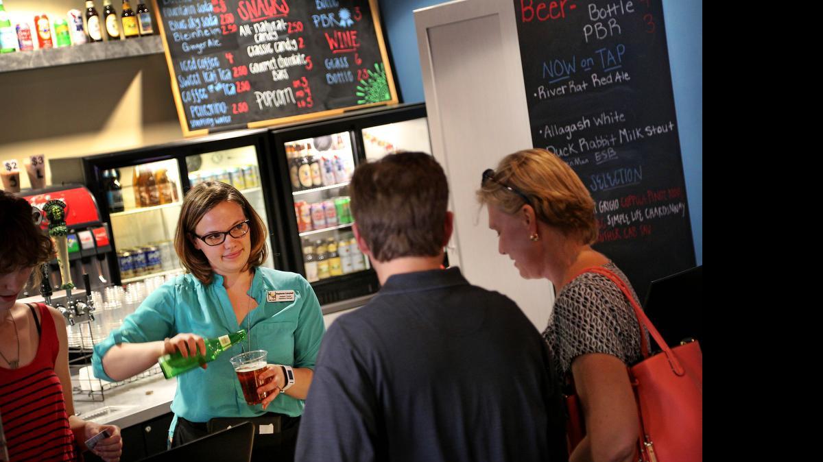 
Stephanie Campbell, an operations manager at Columbia’s downtown Nickelodeon Theatre, serves a beer Thursday to a customer before the start of a movie. The Nick is among the first movie houses in the city to add alcohol to its concessions, an offering that is growing as theaters seek to compete with online movie watching. 
