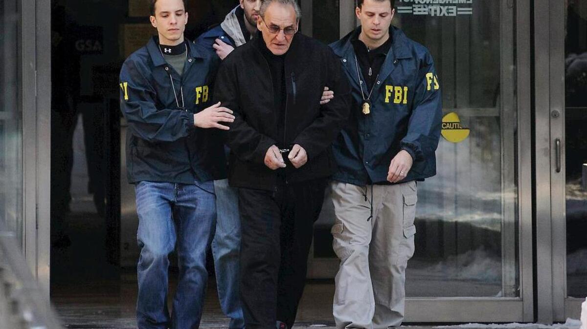 
In this Jan. 23, 2014 file photo, FBI agents flank Vincent Asaro as they escort the reputed mobster from FBI offices in New York. More than 30 years after one of the largest cash robberies in U.S. history, the now 80-year-old Asaro will stand trial in New York for helping to plan the heist that became immortalized in the Martin Scorsese mob movie "Goodfellas." (Charles Eckert/Newsday, via AP, File) NYC OUT
