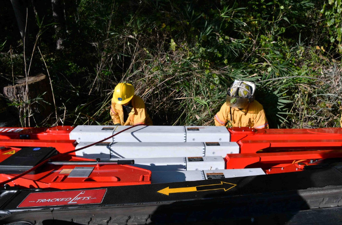An employee was rescued after he became trapped under heavy equipment, crews said.