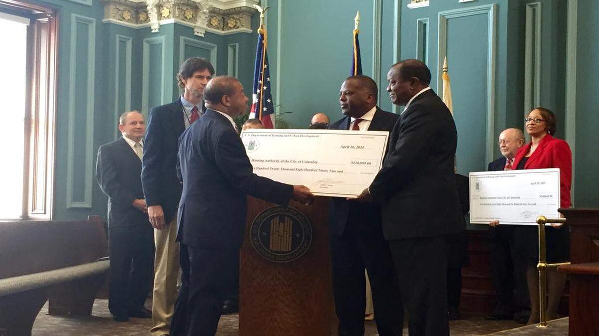 
Columbia Mayor Steve Benjamin and Columbia Housing Authority director Gilbert Walker accept a $220,899 check Monday from the U.S. Department of Housing and Urban Development to go toward housing assistance for homeless veterans in the Columbia area. 
