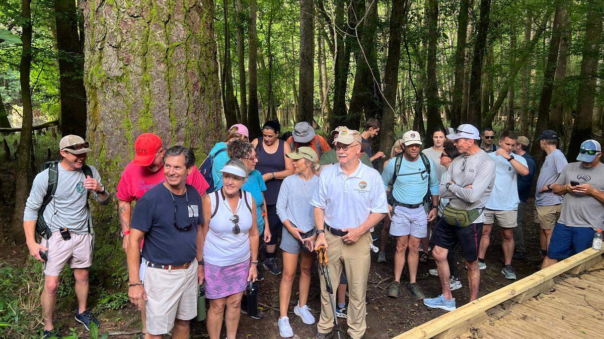 Department of Natural Resources Director Tom Mullikin gathers SC7 Expedition participants for a photo July 15, 2025 in front of a 167-foot loblolly pine, one of the largest trees in the eastern U.S.