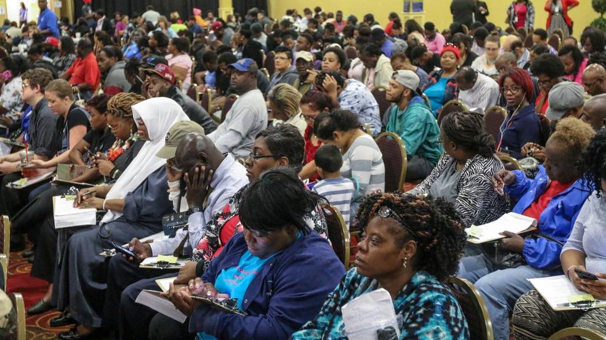 People impacted by the food wait to apply for food assistance at a processing center at The Word of God Church and Ministries.