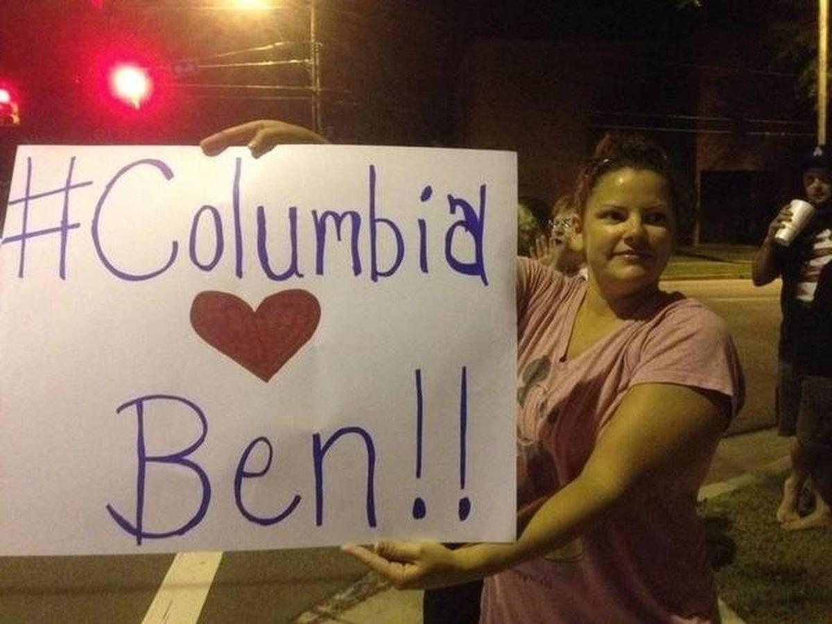 In this file photograph, Kelli Feathers holds up a sign to show her support for anchorman Ben Hoover, after his contract with WIS was not renewed in 2014.