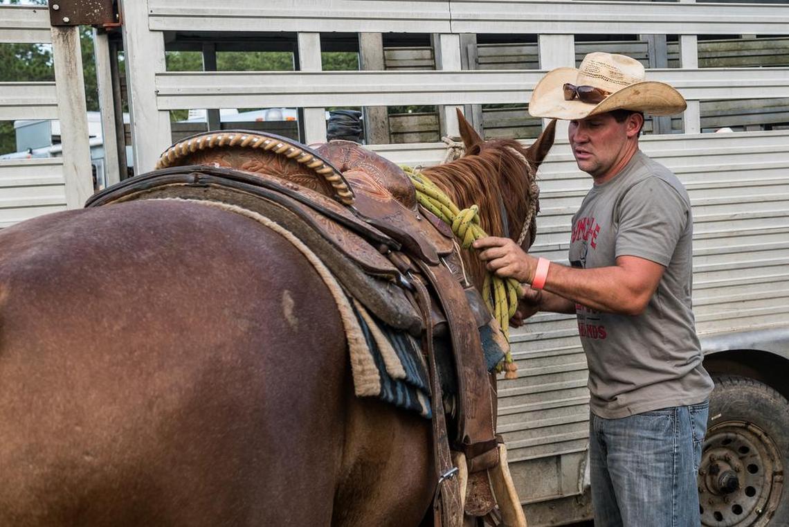 Austin Davis saddles a horse before the beginning of the South Congaree Rodeo a few years ago in west Columbia..