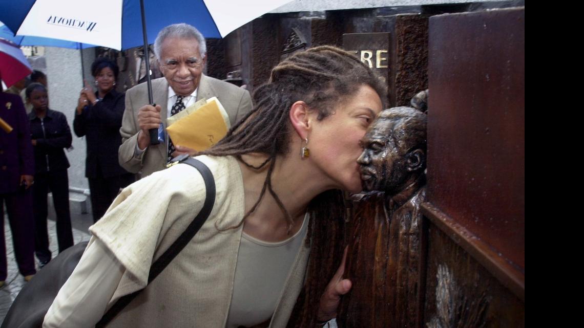 
In 2001, Nikki Finney kisses the likeness of her father, former SC Supreme Court Chief Justice, Ernest A. Finney at a new African American history monument outside the State House. In the background watching is Judge Finney. He was the first African-American Supreme Court chief justice in South Carolina since reconstruction. 

