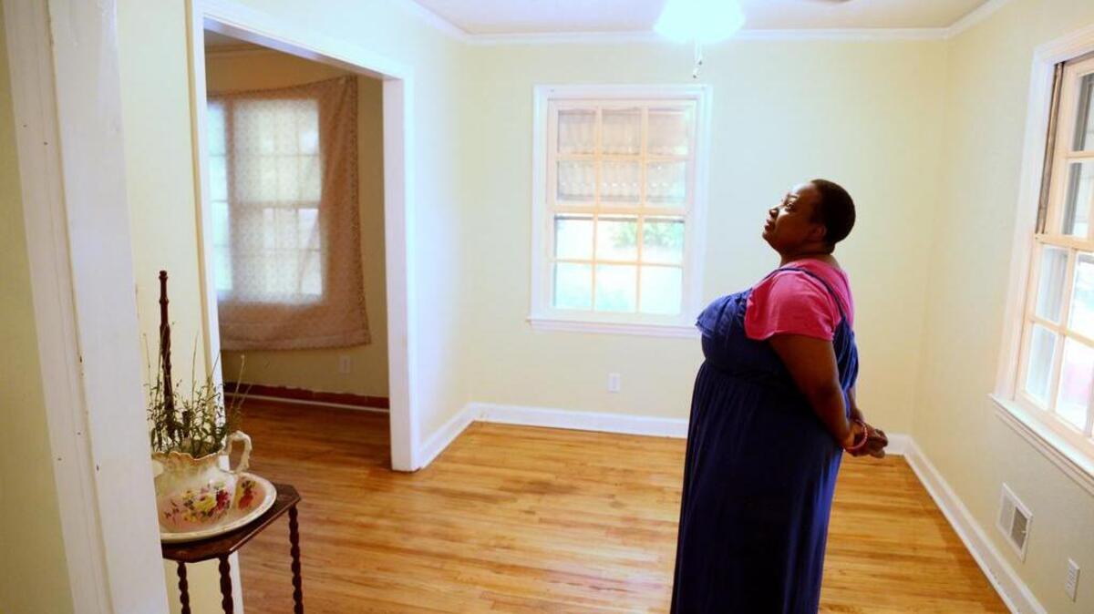 Zelda Benjamin, pictured in 2015, stands in a home she was able to rent thanks to an affordable housing developer.