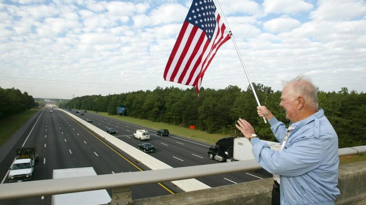 
Leonard Farrington waves an American flag from the Sutton Road bridge over I-77 on Sept. 11, 2003.

