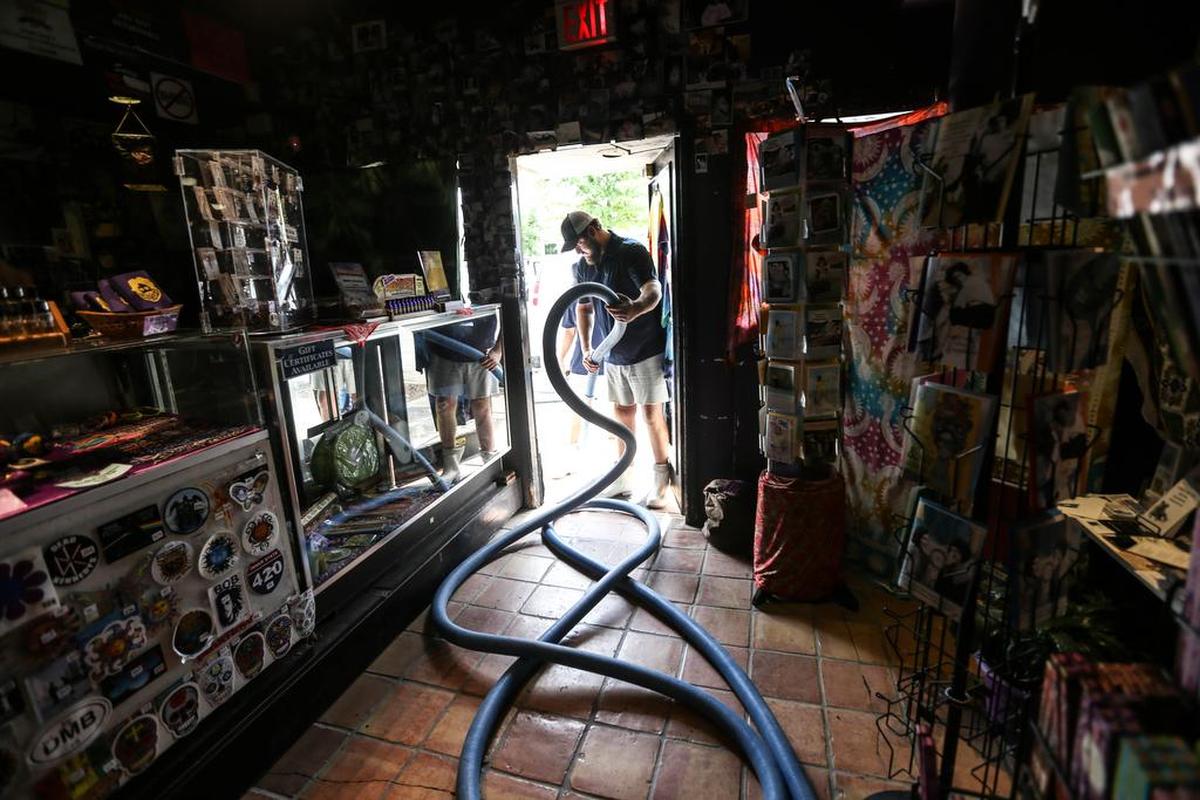 Adam Shealy, of Capital City Carpet Cleaners, cleans More than two dozen Five Points businesses took on water Monday night, with some experiencing only wet floors and others with substantial impact on their inventories.