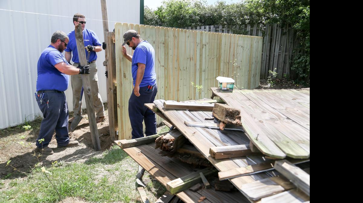 
Travis Branham, left, Blaine Richardson, and Chace Mathias from SCE&G work on improvements at the Samaritan's Well, a transitional home for women and children in Lexington. The volunteers rehabbed the exterior yard, gardens and fencing and made energy efficient modifications to the inside. 
