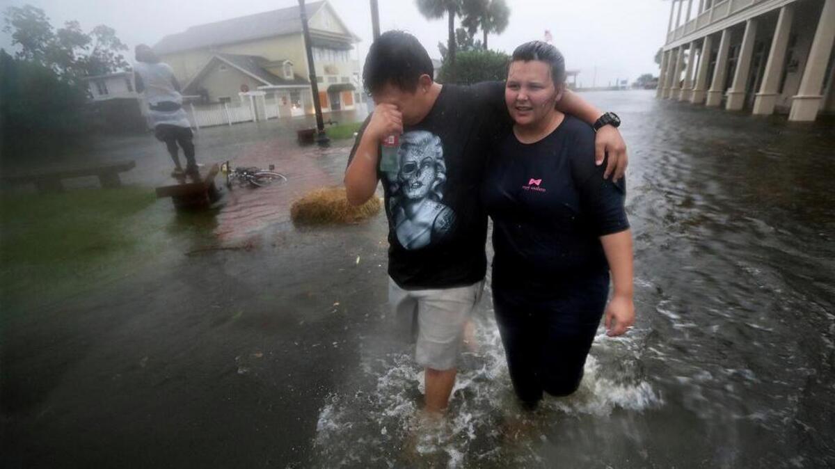 Michael and Tori Munton of Saint Marys, Georgia, make their way through the flooded streets of their town’s historic downtown as storm surge from Hurricane Matthew hit Friday, Oct. 7, 2016. No damage estimate from the storm has been made, but the states affected are sure to request billions from Congress. Funding, however, isn’t certain.
