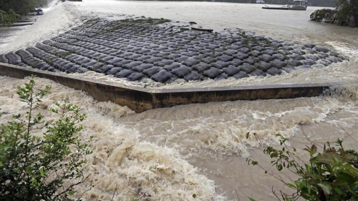 Floodwaters rush over a dam on Forest Lake in Columbia, S.C., in this 2015 photo. State officials in South Carolina are warning dam and pond owners to lower water levels before a possible hit from Hurricane Florence this week.