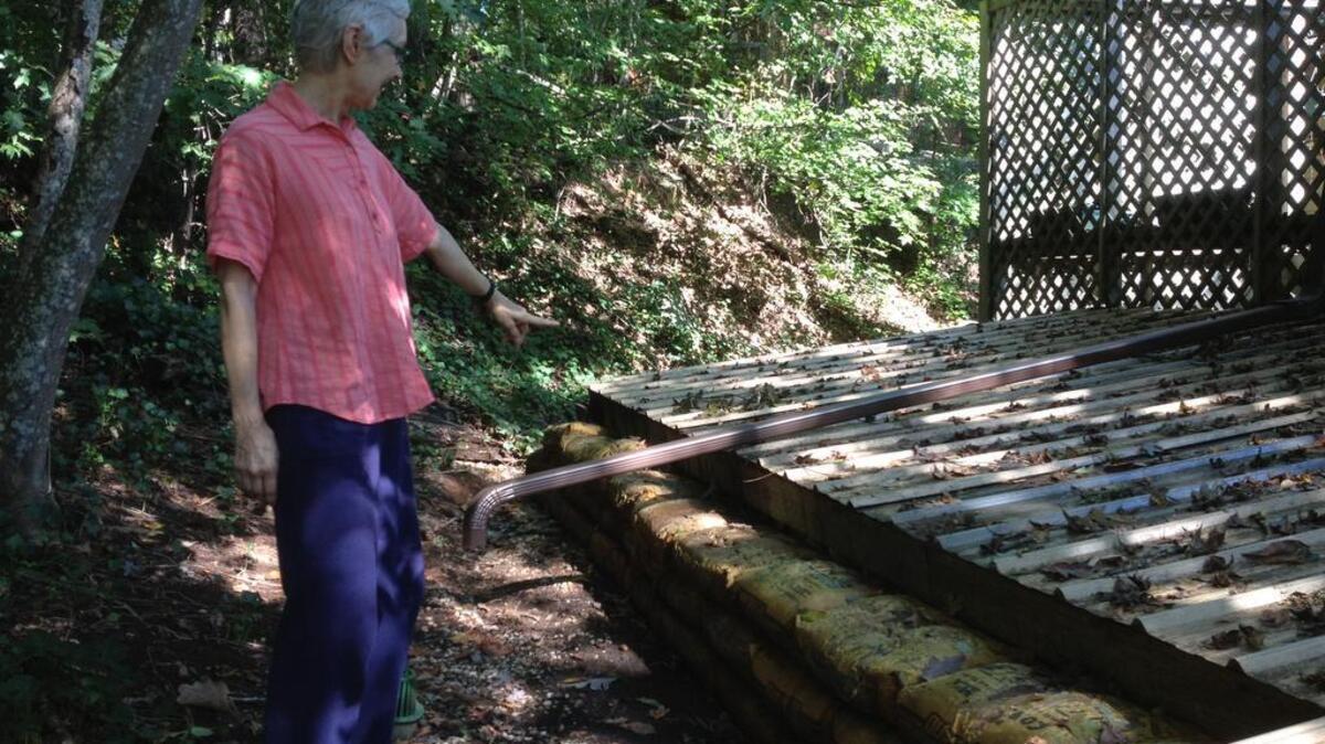 
Linda Sharkey inspects sodden bags of cement placed to protect the back of her home in West Columbia from flooding.
