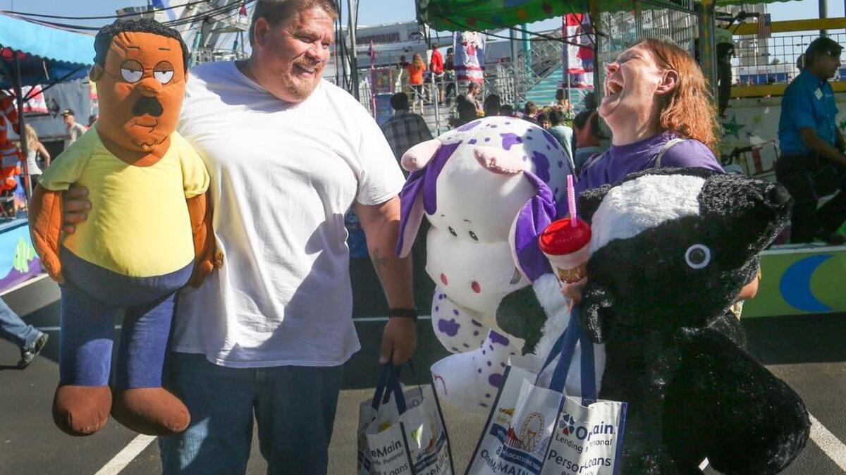 Mike and Teresa Teran of North, enjoy the fair atmosphere while waiting for their children, to ride rides on the first day of the South Carolina State Fair.
