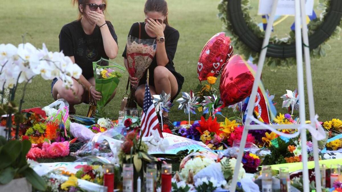 Kelli Cantu 24, left, and Soe Aponte, 23, of Orlando, visit a growing memorial at the Dr. Phillips Center for the victims of the mass shooting over the weekend at Pulse nightclub.