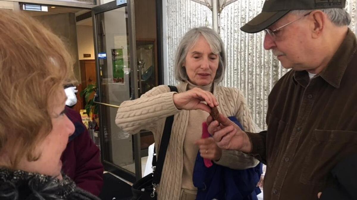 Joseph Katz, right, and wife, Janet, left, try a piece of Mandel bread offered by Leslie Wyatt.
