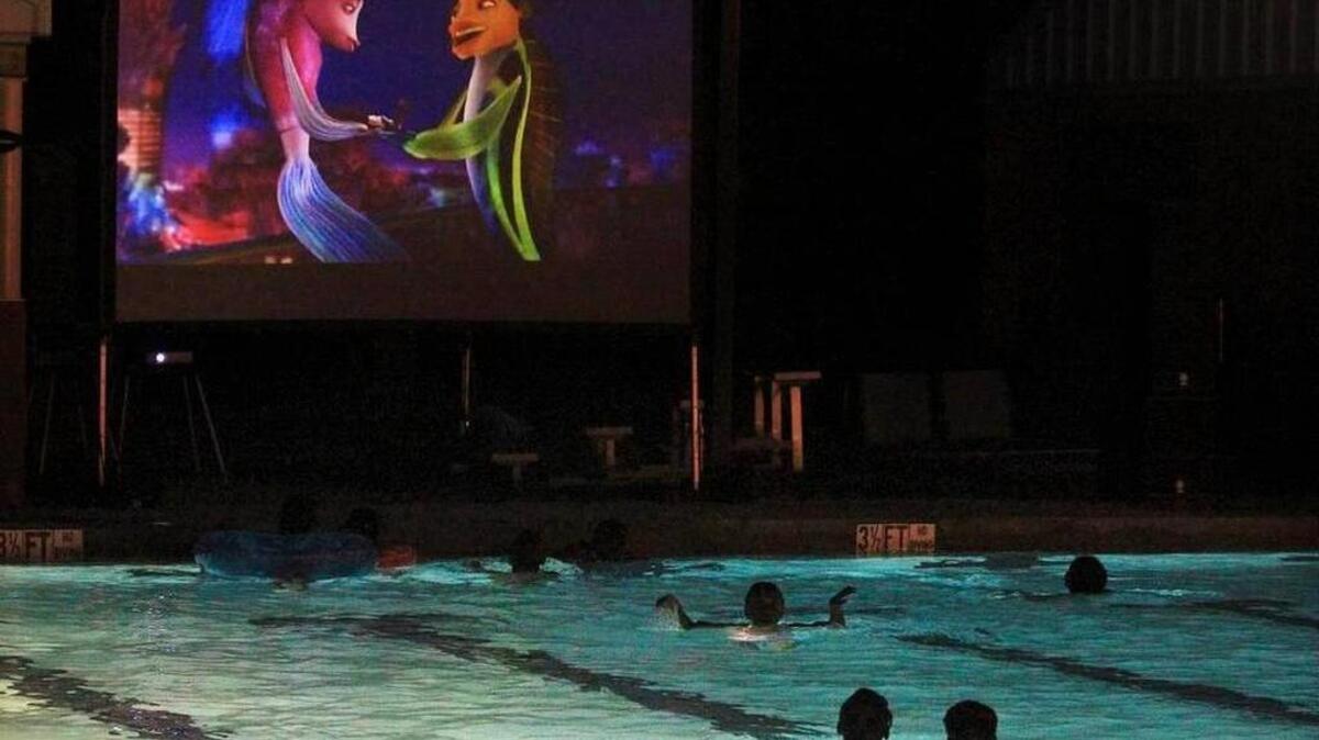Children watch a movie in the outdoor pool that’s part of Maxcy Gregg park.