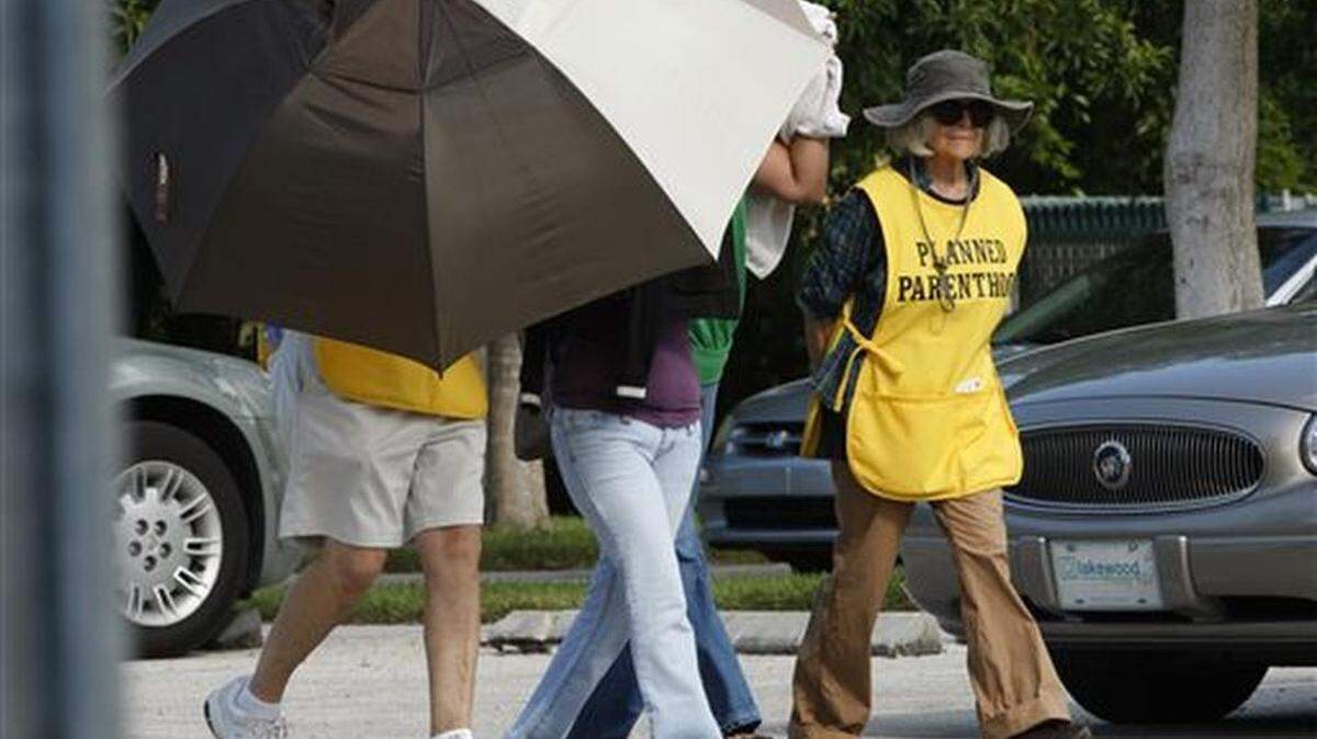 FILE - In this Sept. 14, 2009, file photo, women are concealed from view by Planned Parenthood volunteers as they enter the Planned Parenthood of Collier County in Naples, Fla.