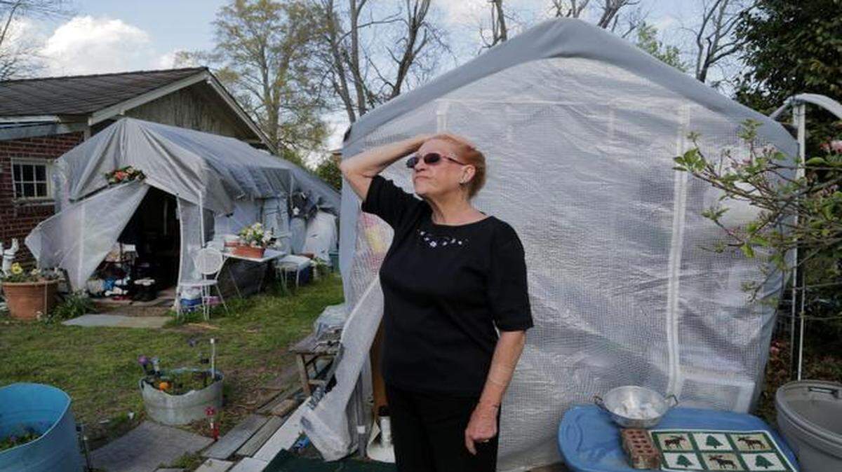 
Amanda Ballenger of Batesburg-Leesville is camping in her yard whiles she presses to have mold removed from her home. The situation developed after her kitchen flooded when a water supply line to her refrigerator burst nearly two years ago. Repairs to a water line in her neighborhood increased water pressure, causing the problem. Ballenger is now fighting local officials and insurers over repairs and safety concerns. Behind her are two tents. One, on the left, houses her bed and the other, a makeshift kitchen. 
