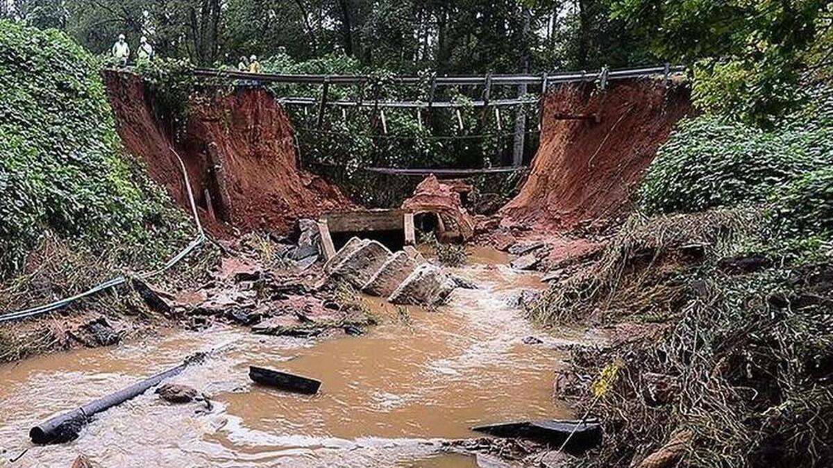 
Emergency responders worked through the night and early morning hours during flooding in Spartanburg early Thursday. Firefighters block the road at Hayne Street near Ethel Road after a cave-in washed away the entire road. One man in a truck was rescued after being swept away in the current.
