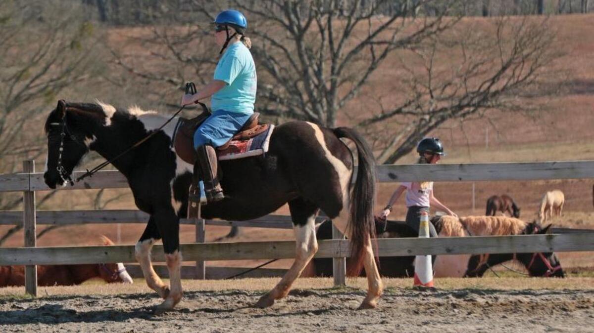 Crystal Collins, left, takes to the ring during her riding lesson on Summer at Scott Hills Equestrian Center in Pendleton.