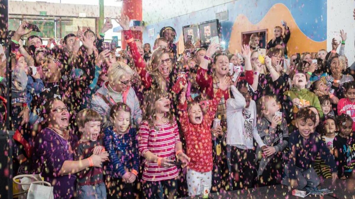 Children and adults alike cheer as confetti rains down