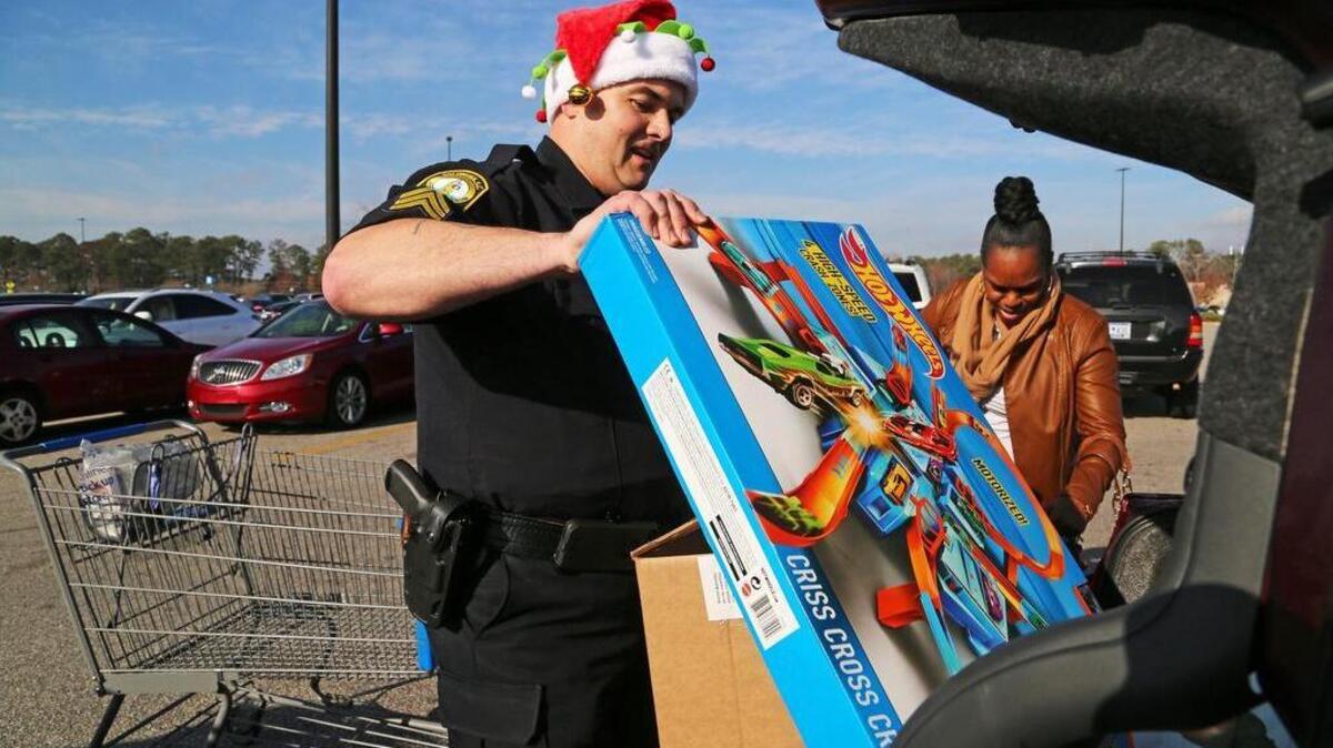 Officer Christopher Morris helps Demetria Goodwin with her holiday items outside of the Wal-Mart on Forest Drive in Columbia, SC, Monday, December 12, 2016. Columbia police officers handed out safety tips for shoppers this holiday season and helped load big items into their cars.