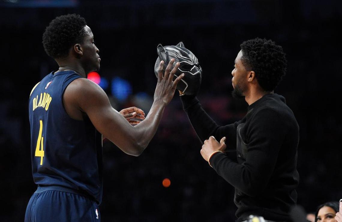 Indiana Pacers' Victor Oladipo, left, takes a mask from the movie "Black Panther" from actor Chadwick Boseman during the NBA basketball All-Star weekend slam dunk contest Saturday, Feb. 17, 2018, in Los Angeles.