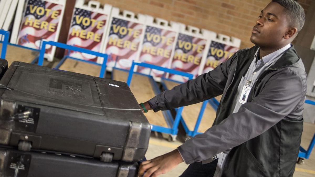 Richland County election machine technician Andre McClaine pulls a cart of voting machines through a warehouse Friday in preparation for the Nov. 8 presidential election. Workers have been loading the machines into trucks for delivery to the county’s 143 polling places.