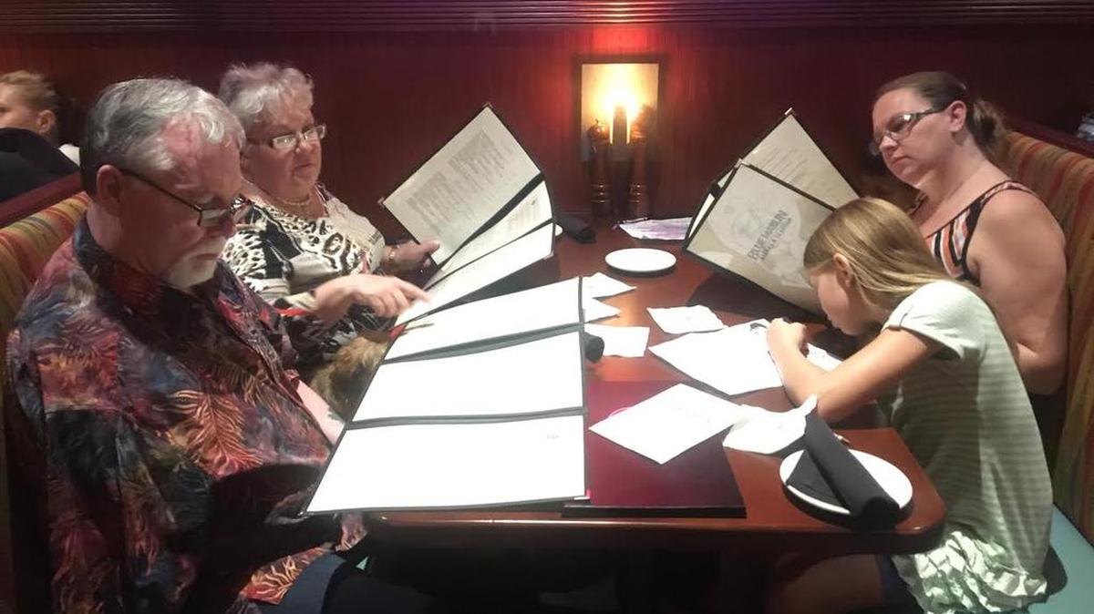 Woody Jones, Chinadoll and Gail Hawkins, of Charleston, left, look over the menu at the Blue Marlin with Meghan McGill and her children Hailey and Alexander.