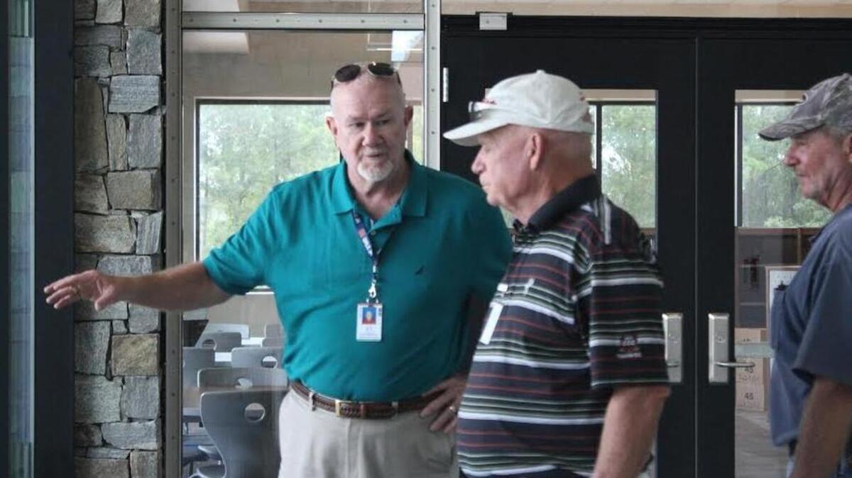 
Lexington-Richland 5 design and construction director Keith McAlister (wearing badge) talks with workers last week about work to complete at Chapin Middle School. 

