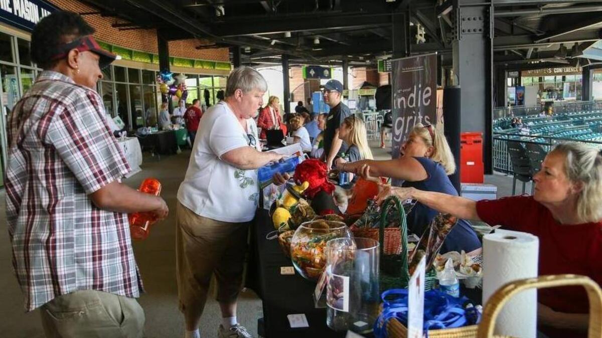 Jackie McDaniel, left, and Joey Beckham collect information about The Pet Oxygen Kit Project, Inc. and other not-for-profit agencies during the annual Midlands Gives event at Spirit Communications Park Tuesday.