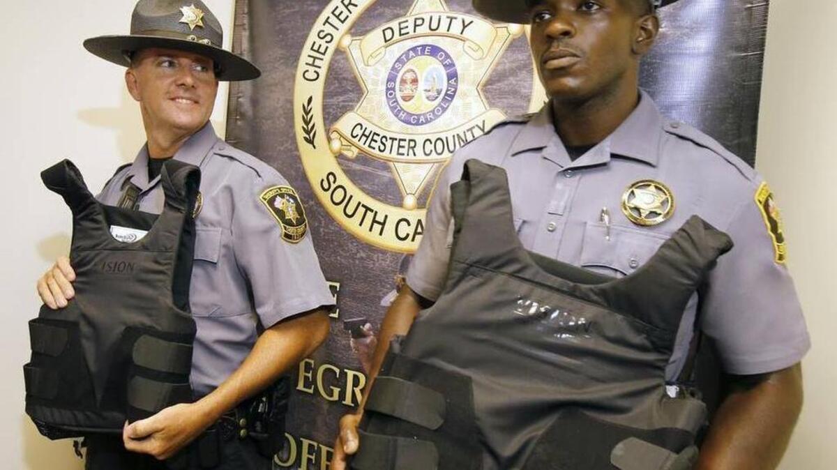 
Chester County Sheriff’s Deputy Cedric Dunn, right, shows off a new bulletproof vest that was paid for by private donations. 
