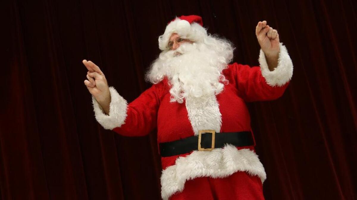 Santa signs to the students.