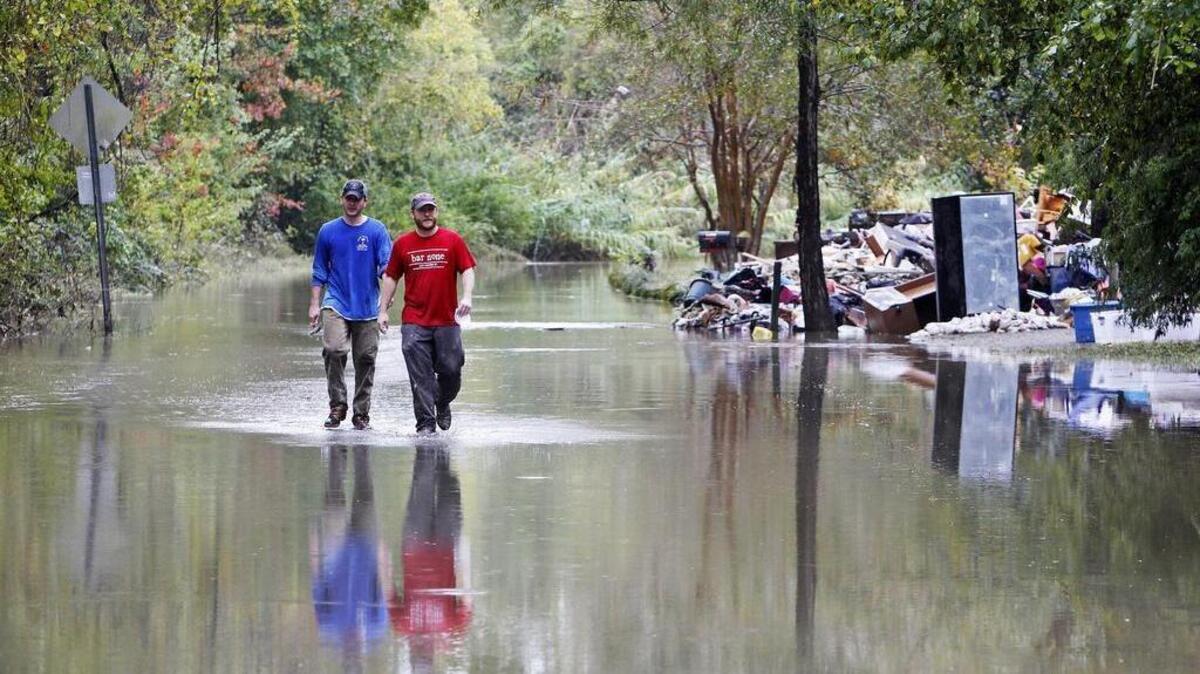 Ricky Spitz and Riley Maxwell helped clean a flooded home on Timberlane Drive in Columbia last month. The storm that dumped more than a foot of water in the region could lead to more isolated flood with new rain this week.
