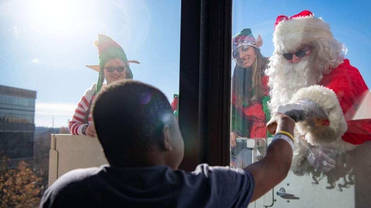 A young patient at Palmetto Health Children’s Hospital fist-bumps Santa Claus, who was raised on a Columbia Fire Department ladder truck to visit with the hospital’s patients through their windows on Christmas Eve. It’s the ninth annual event put on by the hospital and the fire department.