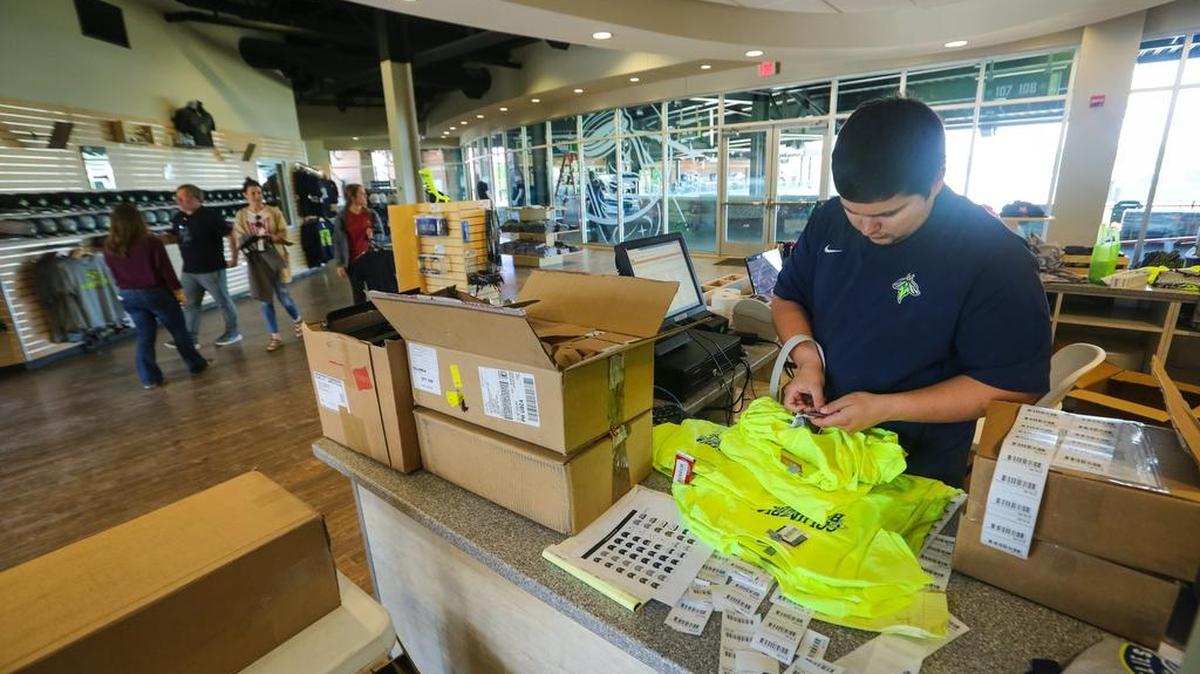 Final preparations are underway at Spirit Communications Park for the first Columbia Fireflies baseball game. Matthew Strader, merchandise manager, tags shirts before displaying them in the Mason Jar Team Store.