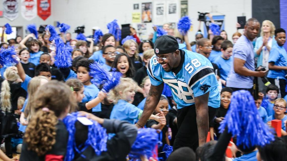 Carolina Panthers linebacker Thomas Davis slaps hands with Leaphart Elementary School students, part of the team’s community outreach locally.