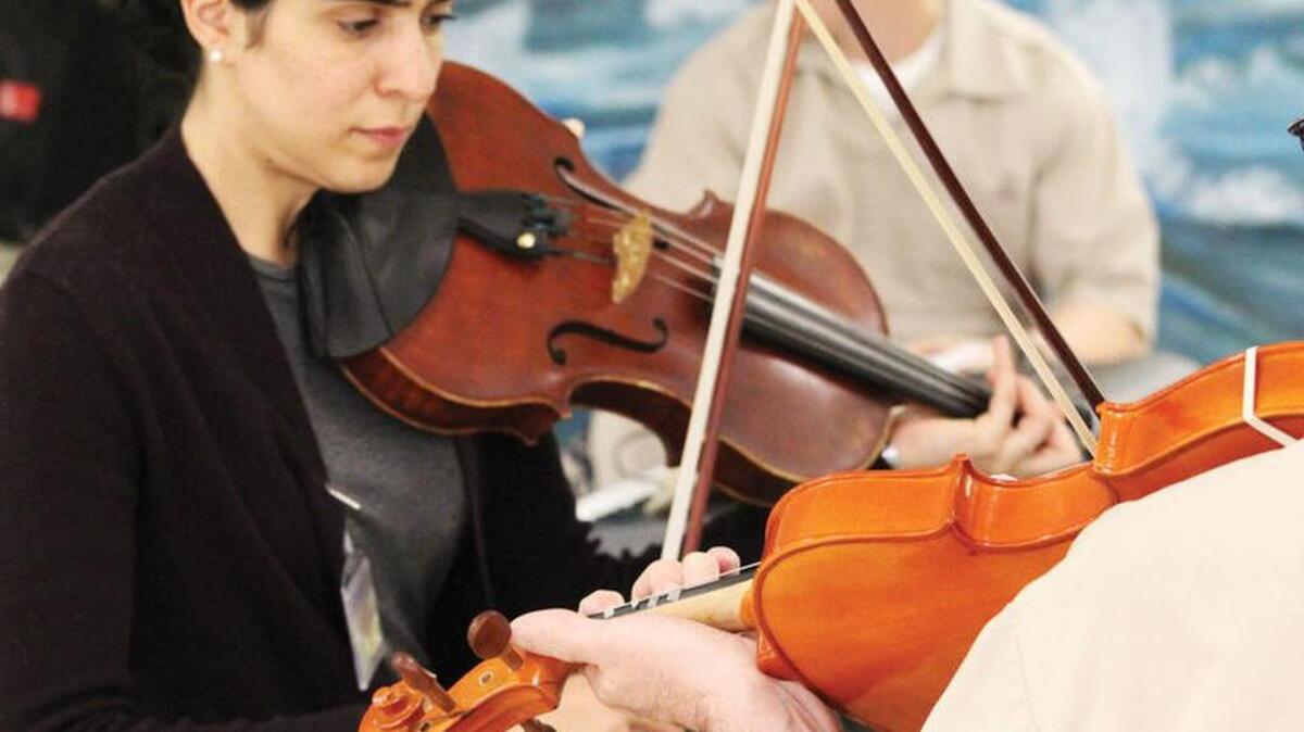 Violist Meena Bhasin works with an inmate during a small group session.