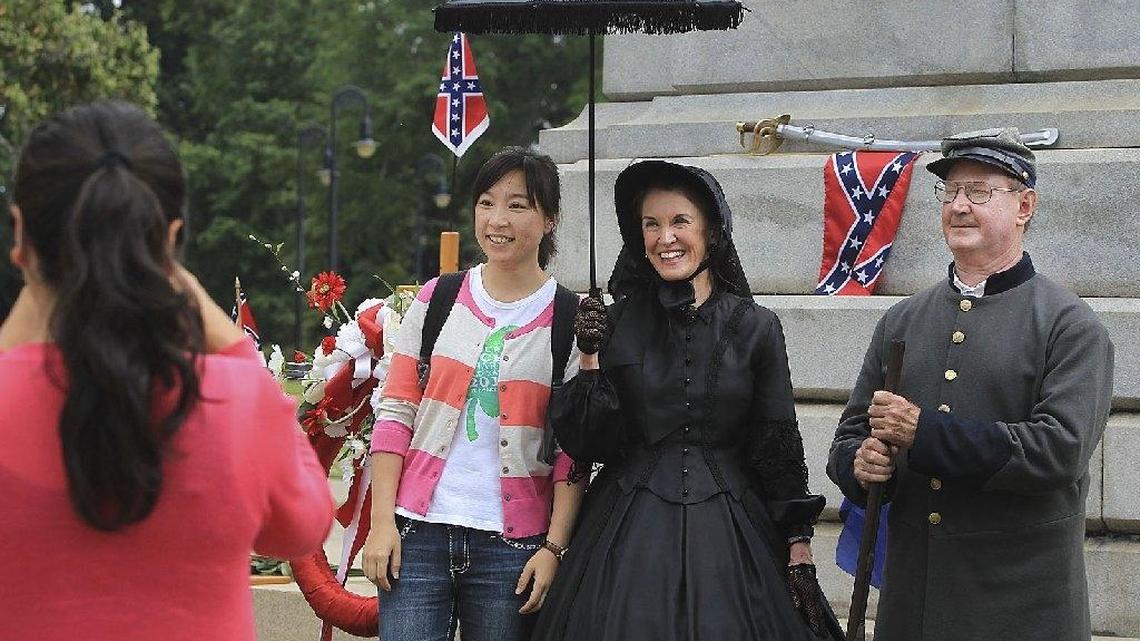 Chinese students, Liming Zhao and Ming Li, touring The Citadel and other places in South Carolina in 2013, stop to get their picture taken with the re-enactors and a better understanding of the holiday. Confederate Memorial Day is a day of remembrance of those Confederate soldiers who died during the American Civil War. Re-enactors Susan Bray, a southern woman in mourning and Francis Marion Hudson, a descendant of Francis Marion the American Revolutionary commander, greet visitors of the State House offering information about the war. Hudson has been making wreaths to place on all of the Confederate monuments for 17 years.