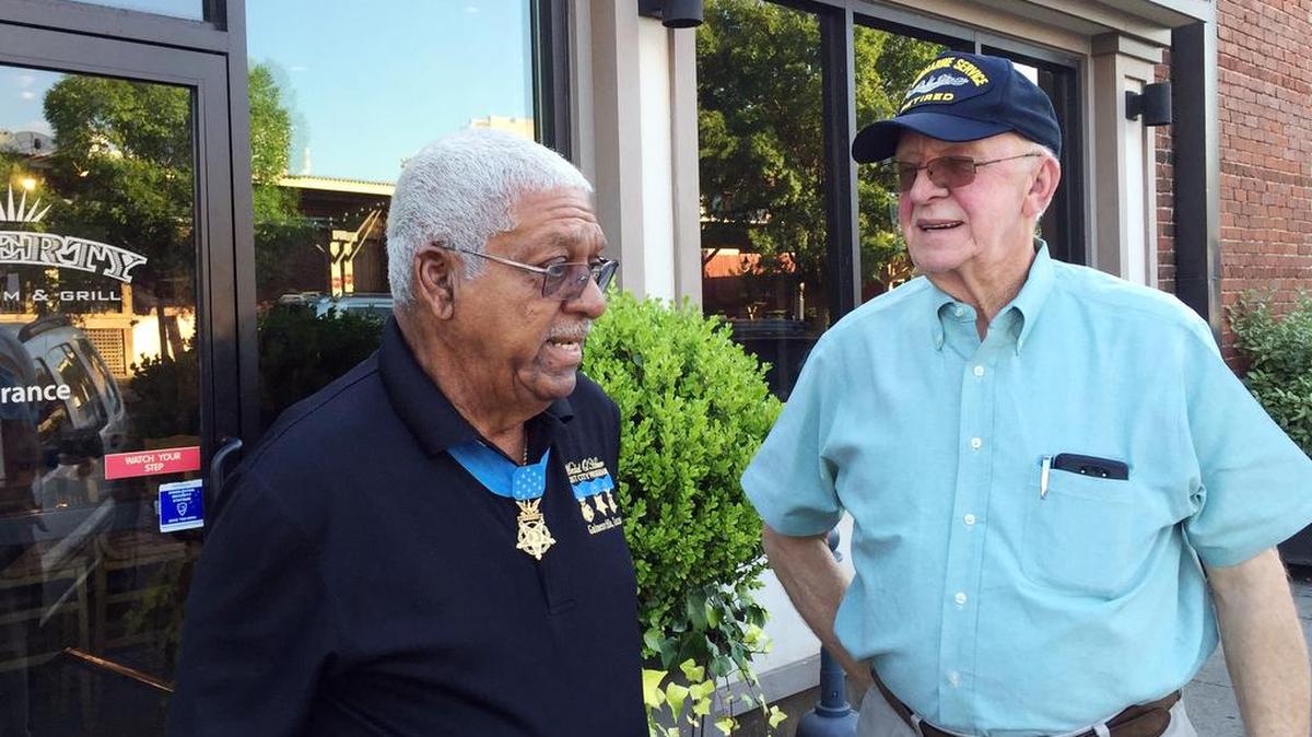 Medal of Honor recipient Melvin Morris (left) talks with Navy veteran Jim Null outside Liberty Tap Room.
