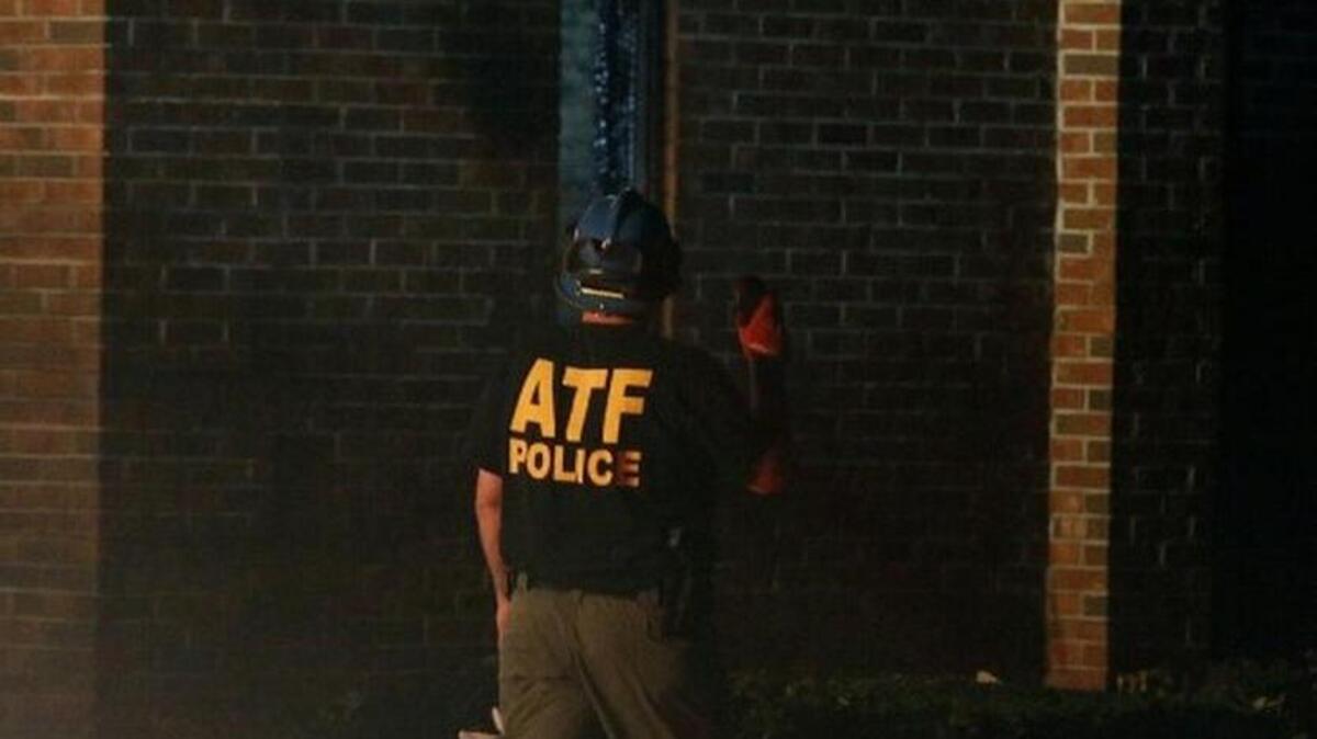 A member of the Bureau of Alcohol, Tobacco, Firearms and Explosives examines the outside of Mount Zion African Methodist Episcopal church, late Tuesday, June 30, 2015, in Greeleyville, S.C. The African-American church, which was burned down by the Ku Klux Klan in 1995, caught fire late Tuesday night.